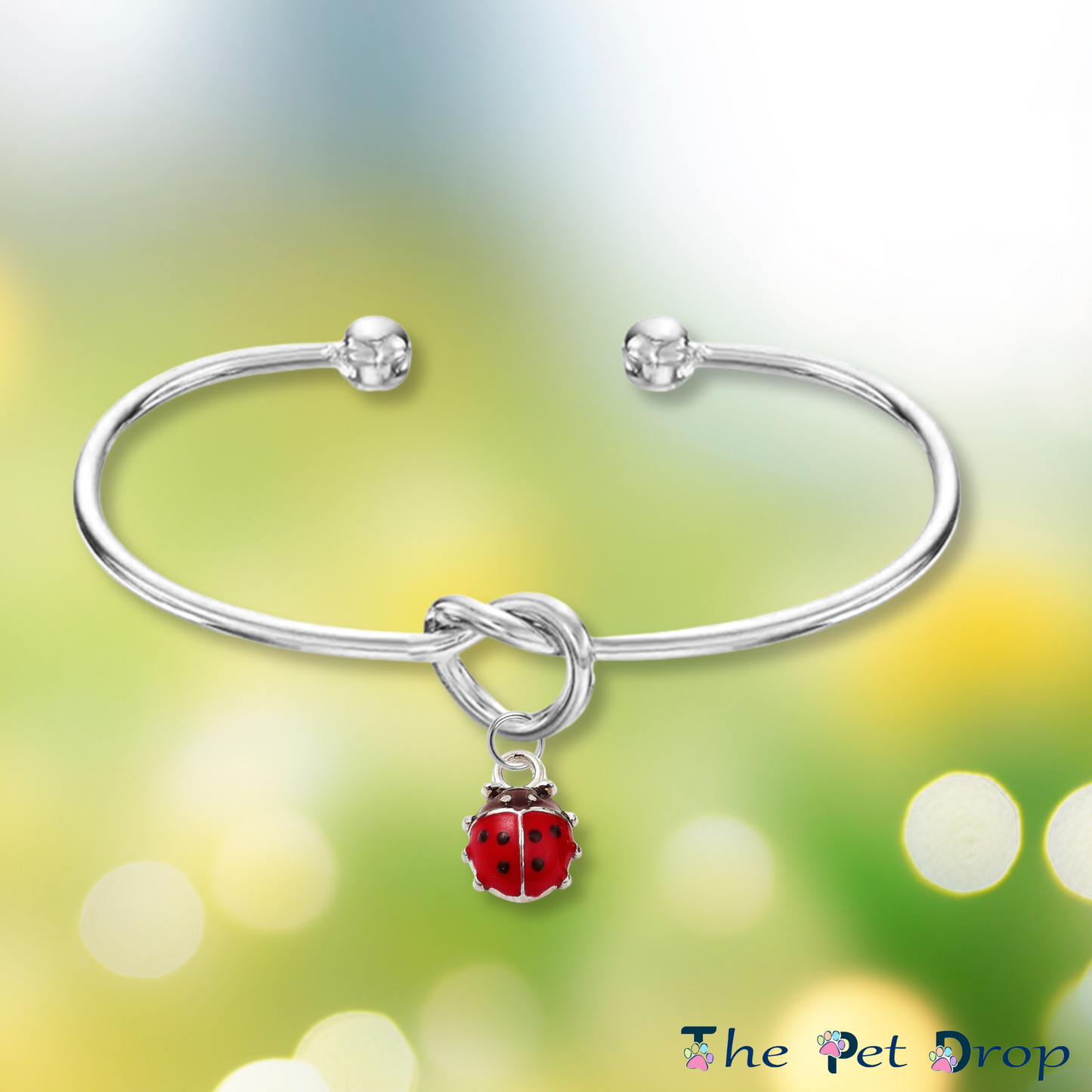 Forever Ladybird Bangle on a green background