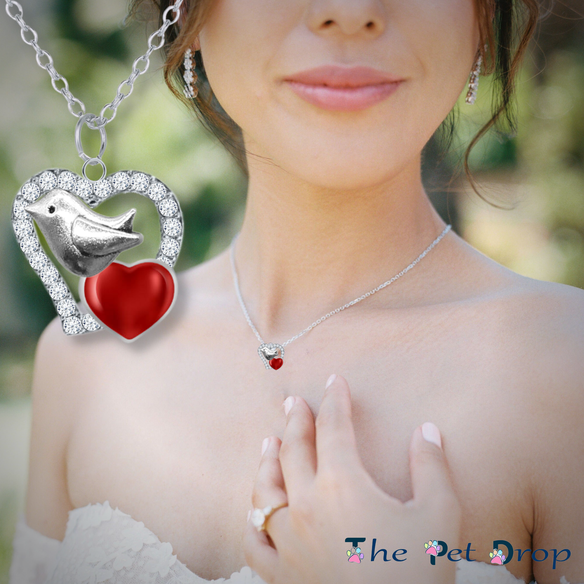 Robin on a crystal heart pendant, with a smaller red heart, hanging from a silver chain on a woman's neck