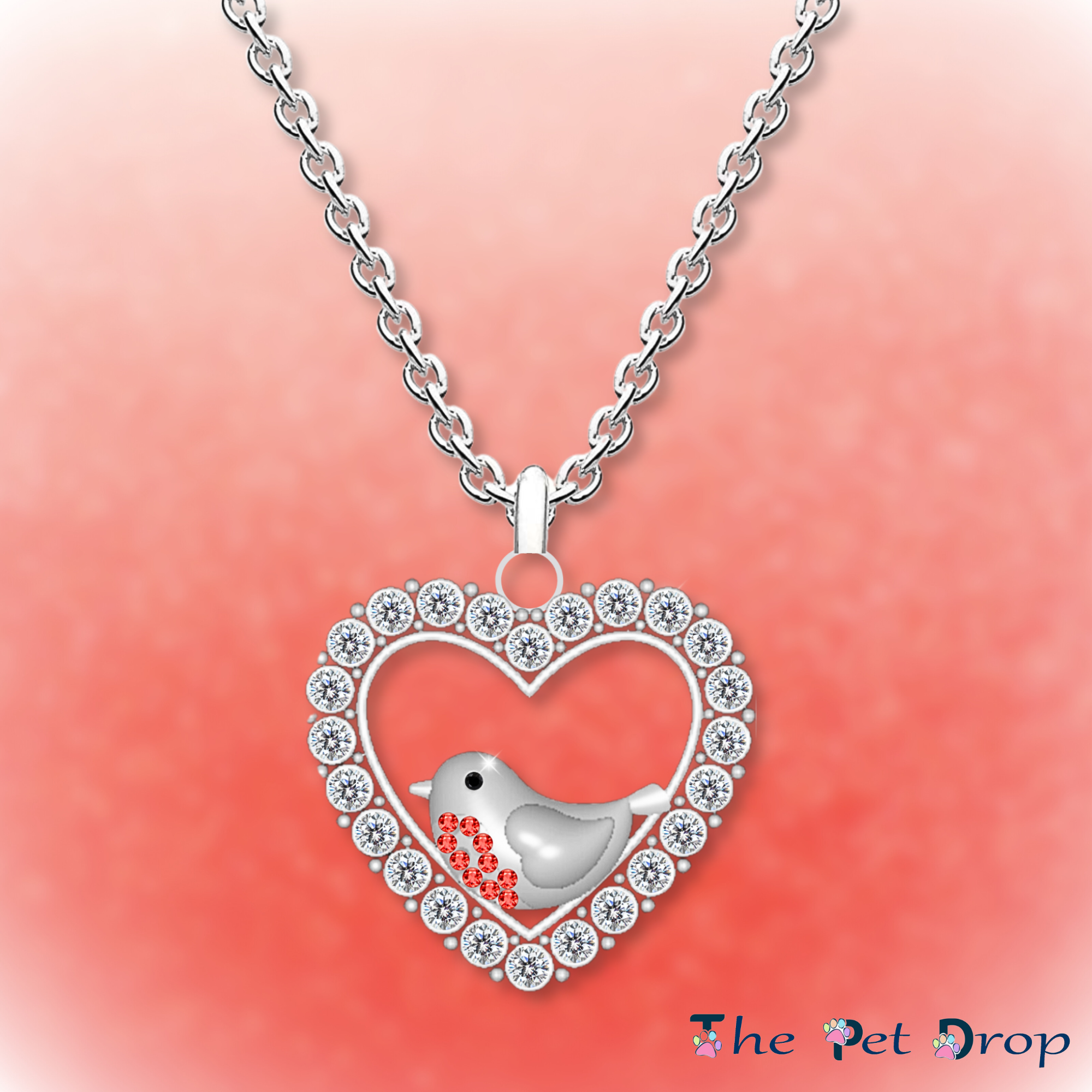 A Robin's Love Necklace. Silver heart shape with white crystals around the edge. Featuring a robin with 9 red crystals on its breast