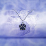 black crystal paw print silver pendant hanging on a silver chain
