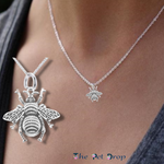 silver bumblebee pendant hanging on a silver chain on a woman's neck