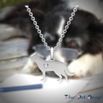 silver standing collie dog pendant with a heart shaped hole in the centre of it hanging from a silver chain.