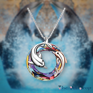 colourful crystal circle with one silver dolphin and a smaller rose gold dolphin in and around the circle pendant hanging on a silver chain.