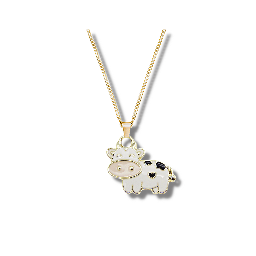 gold outlined white cow with a pale pink nose and 3 black patches hanging on a gold chain