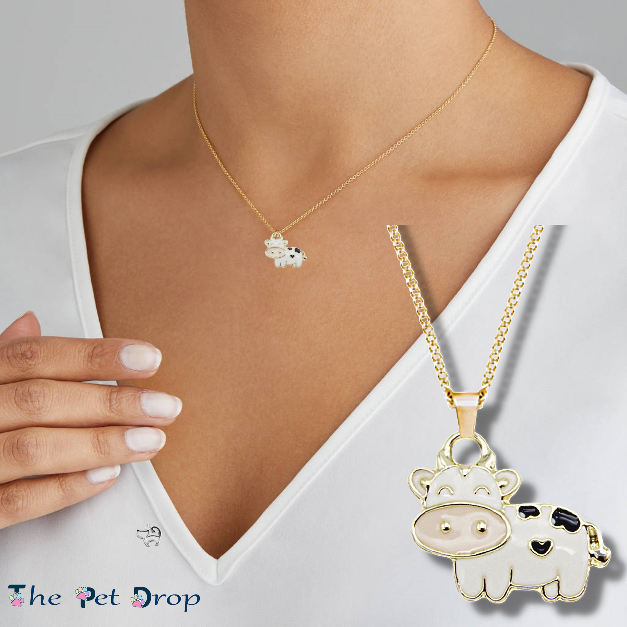 gold outlined white cow with a pale pink nose and 3 black patches hanging on a gold chain on a woman's neck.