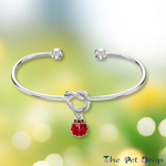 Forever Ladybird Bangle on a green background 