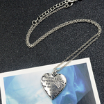 silver heart pendant with a silver crystal paw print on its side in the top corner and the words"no longer by my side... but forever in my heart" written next to the paw print hanging on a silver chain.