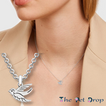 silver flying robin necklace pendant hanging on a silver chain on a woman's neck