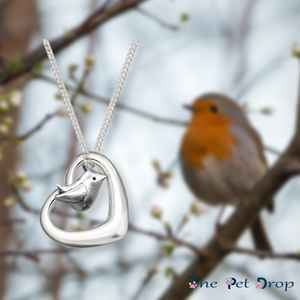 Robin necklace with a robin blurred behind it sitting in a tree