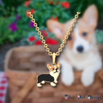 brown, black and white corgi pendant hanging on a gold chain with a gold outlined around the corgi pendant.