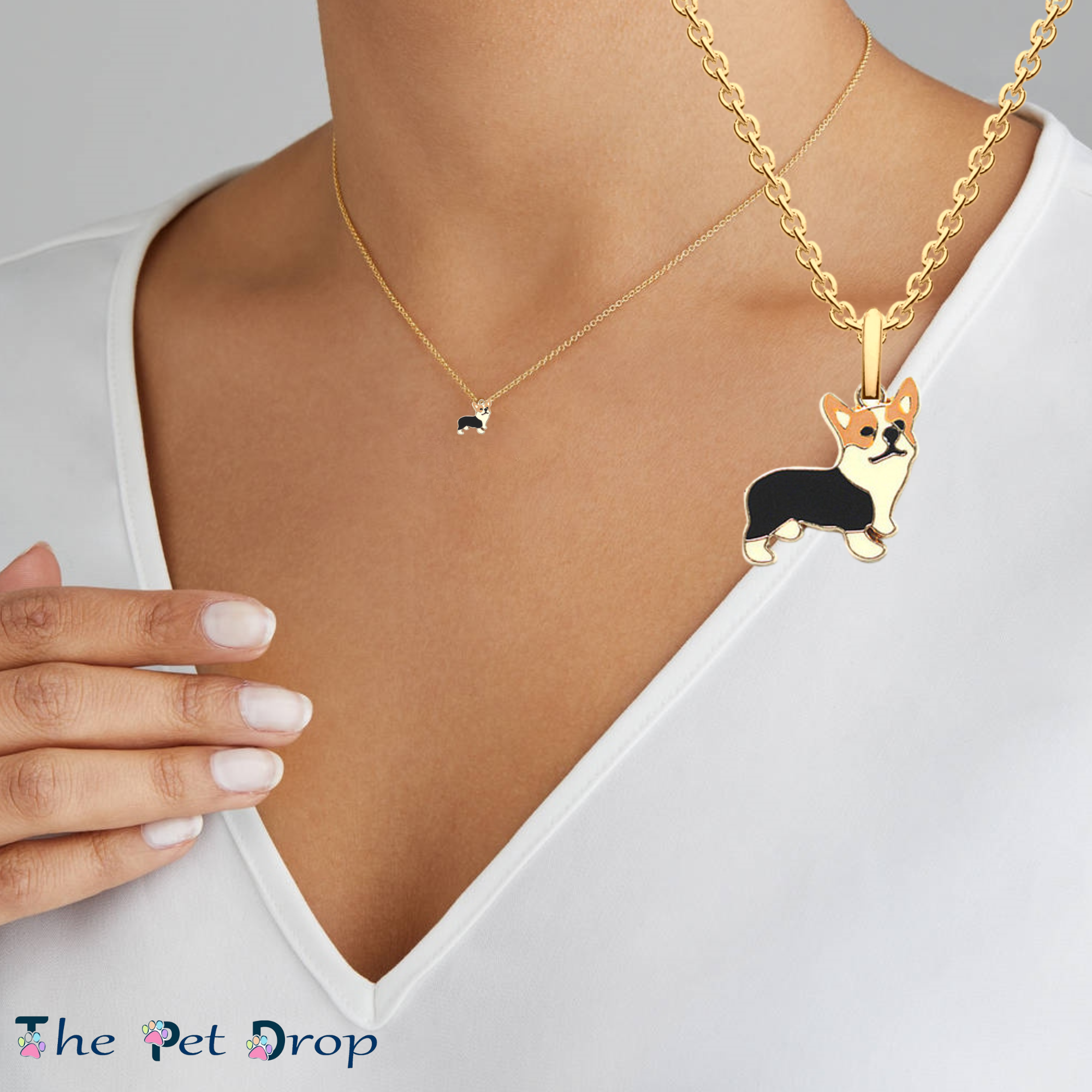brown, black and white corgi pendant hanging on a gold chain with a gold outlined around the corgi pendant on a woman's neck.