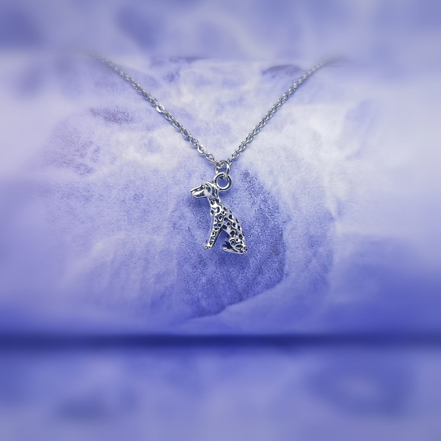 sitting silver Dalmatian pendant hanging on a silver chain   