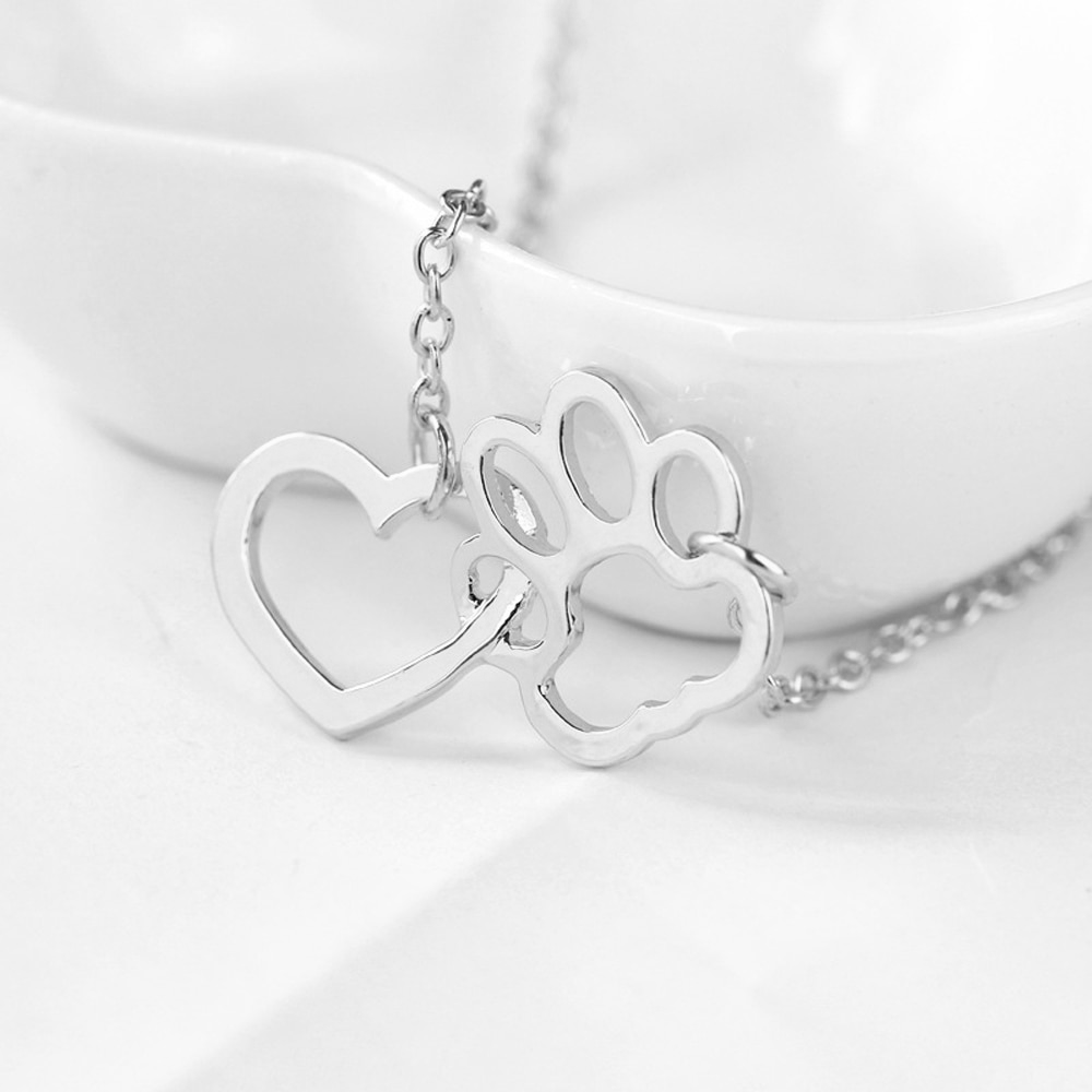 silver heart shape attached to a paw print shape hanging from a silver chain on each side