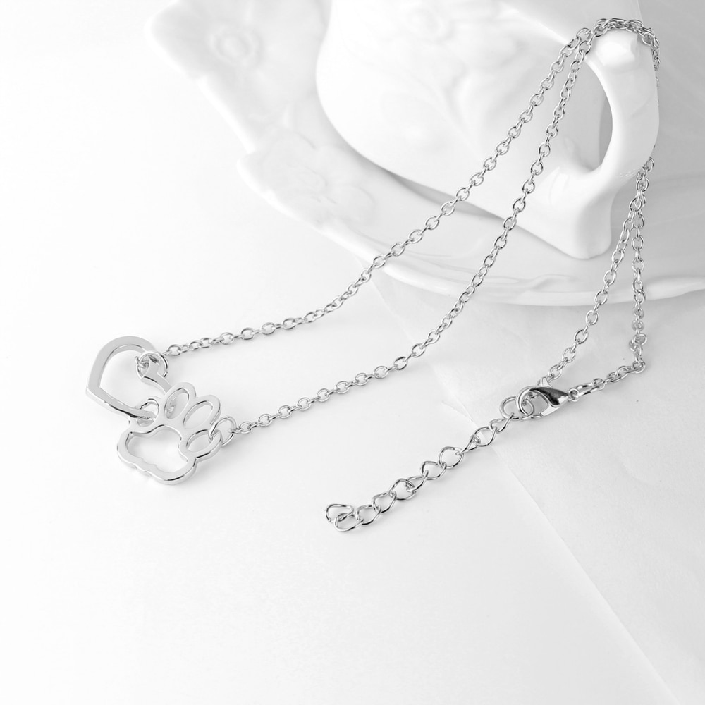 silver heart shape attached to a paw print shape hanging from a silver chain on each side