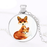 silver circle pendant with an orange fox mother and an orange fox child hanging on a silver chain