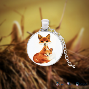 silver circle pendant with an orange fox mother and an orange fox child hanging on a silver chain